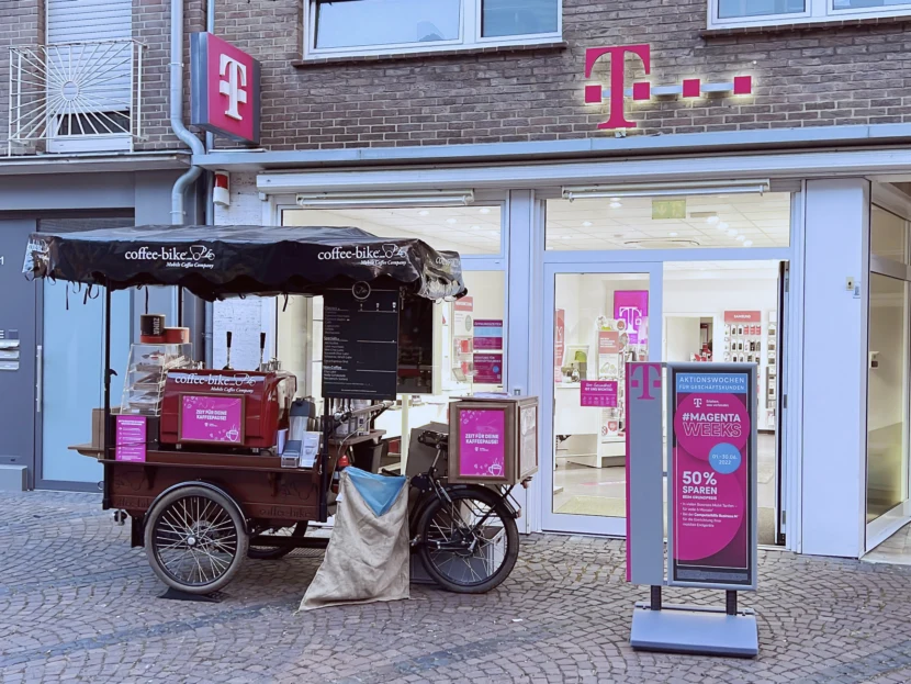 Coffee-Bike macht promotion vor einem Telekom Ladenlokal